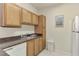 A view of the kitchen featuring light wood cabinets, white appliances, and a grey countertop at 4802 51St W St # 704, Bradenton, FL 34210