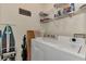 A functional laundry room includes a washer, dryer, shelving, and ironing board at 4802 51St W St # 704, Bradenton, FL 34210
