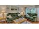 Comfortable living room featuring plush green sofas, wooden coffee table and beautiful decor at 4802 51St W St # 704, Bradenton, FL 34210