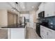 Well-lit kitchen boasts white cabinets, modern appliances, and sleek black countertops and island at 4839 Deep Creek Ter, Parrish, FL 34219