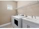 Well-equipped laundry room with modern washer, dryer, sink, and storage, offering convenience at 4839 Deep Creek Ter, Parrish, FL 34219