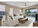 Bright living room with neutral tones, white furniture, and access to outdoor screened patio with water views at 4839 Deep Creek Ter, Parrish, FL 34219