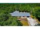 Stunning aerial view of a home featuring a metal roof, driveway, and gorgeous landscaping surrounded by lush greenery at 4876 253Rd E St, Myakka City, FL 34251