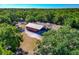 Aerial view of barn featuring a metal roof, stalls, and fenced-in area, surrounded by lush greenery at 4876 253Rd E St, Myakka City, FL 34251