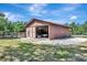Expansive metal barn featuring a full roof, open bay, partial gravel floor, and exterior door at 4876 253Rd E St, Myakka City, FL 34251