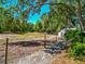 Beautiful countryside view featuring a fenced pasture, a barn, and mature trees at 4876 253Rd E St, Myakka City, FL 34251