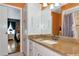Bathroom featuring granite counters, step-in shower, and a view into a bedroom at 4876 253Rd E St, Myakka City, FL 34251