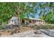 Charming home with a metal roof, a welcoming porch, and beautiful landscaping at 4876 253Rd E St, Myakka City, FL 34251