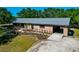 Charming home with a metal roof, covered porch, carport, and beautifully landscaped front yard at 4876 253Rd E St, Myakka City, FL 34251