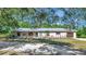 Single story home with metal roof, covered porch and colorful landscaping in front at 4876 253Rd E St, Myakka City, FL 34251