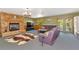 Comfortable living room with a fireplace, purple sofa, and a large window at 4876 253Rd E St, Myakka City, FL 34251