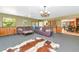 Spacious living room featuring a purple leather sofa and adjacent to a dining area at 4876 253Rd E St, Myakka City, FL 34251