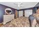 Charming main bedroom featuring hardwood floors, round mirror, and dark purple accent wall at 4876 253Rd E St, Myakka City, FL 34251