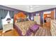 Charming main bedroom with hardwood floors, wood headboard, and purple accent wall and decor at 4876 253Rd E St, Myakka City, FL 34251