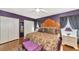 Charming main bedroom featuring hardwood floors, unique headboard, and dark purple accent wall at 4876 253Rd E St, Myakka City, FL 34251