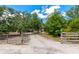 Gravel road leads to a gated residence through lush, mature trees with signage at 4876 253Rd E St, Myakka City, FL 34251