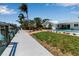 Waterfront home featuring a dock, lush lawn, pool, spa, and outdoor entertainment area at 519 74Th St, Holmes Beach, FL 34217