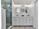 Bright bathroom features a double vanity with white cabinets and a glass enclosed shower at 519 74Th St, Holmes Beach, FL 34217
