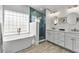 Luxurious bathroom featuring a soaking tub, a glass-enclosed shower, double vanities, and modern fixtures at 519 74Th St, Holmes Beach, FL 34217
