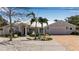 Charming home with a light gray exterior, white trim, metal roof, and a well-manicured lawn with palm trees at 519 74Th St, Holmes Beach, FL 34217