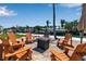 Waterfront seating area features a fire pit surrounded by comfortable Adirondack chairs at 519 74Th St, Holmes Beach, FL 34217