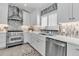 Bright kitchen features white cabinets, stainless steel appliances, a decorative backsplash, and white countertops at 519 74Th St, Holmes Beach, FL 34217