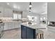 Spacious kitchen with island, white cabinets, and stainless appliances, offering a seamless blend of style and functionality at 519 74Th St, Holmes Beach, FL 34217