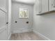Clean, simple laundry room featuring sleek white cabinets, a window, and modern flooring at 519 74Th St, Holmes Beach, FL 34217