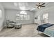 Bright primary bedroom features a ceiling fan, shuttered windows, and doorway to the en-suite bathroom at 519 74Th St, Holmes Beach, FL 34217