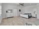 Bright primary bedroom features coastal decor, a ceiling fan, and light wood floors and a view to the en-suite at 519 74Th St, Holmes Beach, FL 34217