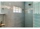Modern blue tiled shower stall features a glass block window and stylish fixtures at 519 74Th St, Holmes Beach, FL 34217