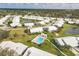 Aerial view of community showcasing pool with lounge chairs, lush landscaping, serene ponds and surrounding homes at 5448 Crestlake Blvd # 158, Sarasota, FL 34233