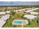 Aerial view showcases community pool surrounded by lush lawns and mature trees, with homes in the background at 5448 Crestlake Blvd # 158, Sarasota, FL 34233