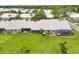 A picturesque aerial view shows the home's manicured lawn, screened patio, and neighboring residences at 5448 Crestlake Blvd # 158, Sarasota, FL 34233