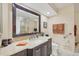 Well-lit bathroom featuring a marble countertop, large dark wood framed mirror and modern fixtures at 5448 Crestlake Blvd # 158, Sarasota, FL 34233