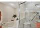 Bright bathroom showcasing a tub, marble tiling and glass door shower with a hand rail at 5448 Crestlake Blvd # 158, Sarasota, FL 34233