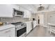 Bright kitchen showcases stainless appliances, sleek white cabinetry, mosaic tile backsplash, and dining space at 5448 Crestlake Blvd # 158, Sarasota, FL 34233