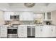 A modern kitchen featuring stainless steel appliances, light countertops and backsplash, and white cabinets at 5448 Crestlake Blvd # 158, Sarasota, FL 34233