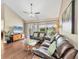 Bright living room featuring hardwood floors, fan, and a large window offering a view of the outdoors at 5448 Crestlake Blvd # 158, Sarasota, FL 34233