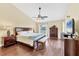 A main bedroom featuring wood floors, vaulted ceiling, ceiling fan, and abundant natural light at 5448 Crestlake Blvd # 158, Sarasota, FL 34233