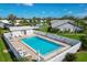 Inviting community pool with patio chairs, lush landscaping, privacy fence, and clear blue water at 5448 Crestlake Blvd # 158, Sarasota, FL 34233