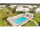 An aerial view of a community pool with lounge chairs, landscaping, a fence and palm trees at 5448 Crestlake Blvd # 158, Sarasota, FL 34233