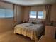Cozy bedroom with multiple windows, a patterned quilt and wood laminate floors at 5536 Denmark Dr, Bradenton, FL 34207