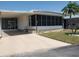 Charming home featuring a well-manicured lawn, carport, and a screened-in porch for outdoor enjoyment at 5536 Denmark Dr, Bradenton, FL 34207