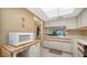 Kitchen features a garden window, white cabinets, and tile floors at 5649 Summerside Ln # 41B, Sarasota, FL 34231