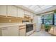 Bright kitchen features white appliances, cabinetry, and a garden window at 5649 Summerside Ln # 41B, Sarasota, FL 34231
