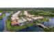 Community aerial view featuring homes with screened pools, lush landscaping, and a scenic pond with a bridge at 5751 Wilena Pl, Sarasota, FL 34238
