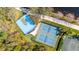 Aerial view of the sports courts featuring tennis and basketball courts surrounded by lush landscaping at 5751 Wilena Pl, Sarasota, FL 34238