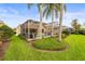 Beautiful backyard featuring a screened-in lanai with a swimming pool, lush landscaping, and tall palm trees at 5751 Wilena Pl, Sarasota, FL 34238