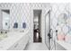 Bright bathroom with dual sinks, shower, and stylish blue and white patterned wallpaper at 5751 Wilena Pl, Sarasota, FL 34238